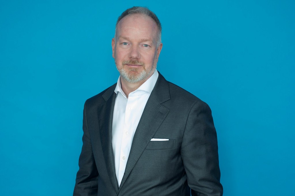 WildBrain appoints Mark Trachuk as general counsel Portrait photo of WildBrain general counsel Mark Trachuk in a white shirt and grey suit, in front of a blue background.